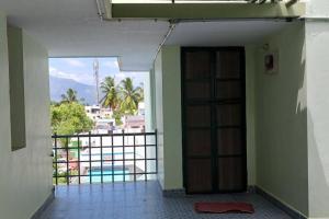 Cette chambre dispose d'une porte et offre une vue sur la piscine. dans l'établissement A Sweet home Homestay Second Floor, à Palni