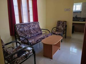 - un salon avec deux chaises et une table dans l'établissement A Sweet home Homestay Second Floor, à Palni