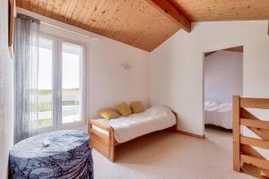 a bedroom with a bed and a large window at Paisible escale à Talmont-Saint-Hilaire avec piscine in Saint-Jean-dʼOrbetiers