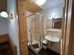 uma casa de banho com um chuveiro e um lavatório. em Gasthaus Bad Siess em Longostagno