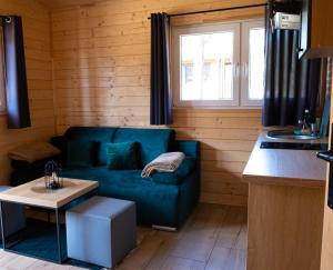 ein Wohnzimmer mit einem blauen Sofa und einem Tisch in der Unterkunft Osada Lubniewice - Domki letniskowe nad samym jeziorem na wynajem 2-8osób in Lubniewice