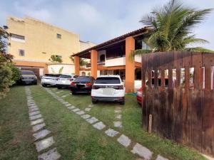 a row of cars parked in front of a building at Pousada Casa Da Arara suíte 104 in Saquarema