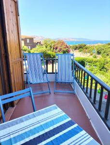 two blue chairs sitting on a balcony with the ocean at La Finestra Sul Mare in Stintino