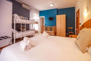 a bedroom with two bunk beds and a crib at Hotel Hc Resort Lignano in Lignano Sabbiadoro