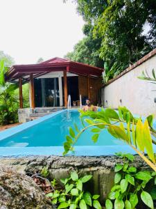 a man laying in a pool next to a house at Sindu Grand Cabana Bentota in Bentota