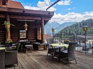 a deck with tables and chairs on a log cabin at Tirolerhof - inklusive Super Sommer Card in Serfaus