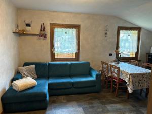 ein Wohnzimmer mit einem blauen Sofa und einem Tisch in der Unterkunft Appartamento Divina in Valdisotto