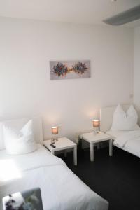 una camera con due letti e due tavoli con lampade di Ein, Zwei- oder Mehrbettzimmer/ Monteurszimmer a Lipsia