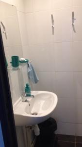W białej łazience znajduje się umywalka i lustro. w obiekcie Résidence Zola w Hawrze