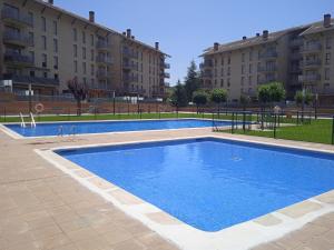 une grande piscine en face de certains bâtiments dans l'établissement Alquiler piso verano/invierno, à Jaca