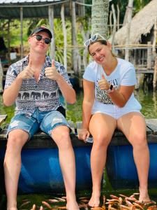 een man en een vrouw die op een boot zitten en duimen opsteken bij Sindu Grand Cabana Bentota in Bentota