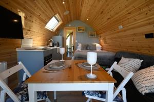 cocina y sala de estar con mesa en una cabaña en Macree Pod, en Taynuilt