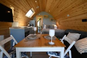 a kitchen and a living room with a table in a cabin at Macree Pod in Taynuilt