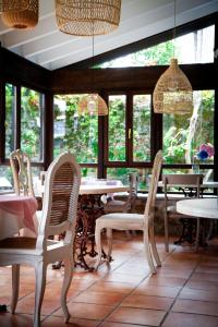 a dining room with chairs and tables and windows at Hotel La Casona de Nueva in Nueva de Llanes