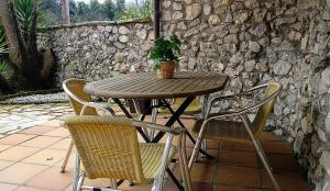 uma mesa de madeira com cadeiras e um vaso de plantas sobre ela em Villa Natalia Loft Rural em Llanes