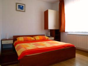 a bedroom with a bed with orange and yellow sheets at House Sekulic in Grabovac