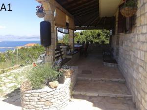 a stone house with a view of the ocean at Apartments Belvedere - A1 in Nečujam