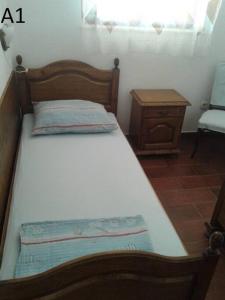 a bedroom with a bed and a chair and a window at Apartments Belvedere - A1 in Nečujam