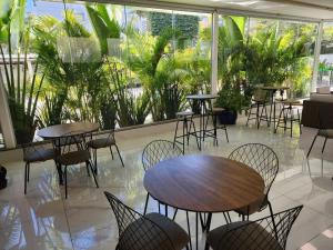a restaurant with tables and chairs and plants at Hotel Appel in Santa Maria