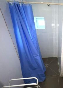 - un rideau de douche bleu dans la salle de bains pourvue d'une chaise dans l'établissement Maison avec terrasse - 12 personnes, à Saint-Yan