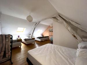 - une chambre avec un lit et une chambre avec des canapés dans l'établissement Maison avec terrasse - 12 personnes, à Saint-Yan