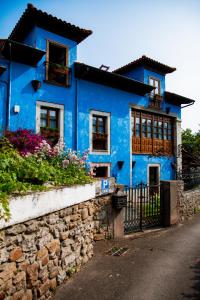 una casa azul con flores delante en Hotel La Casona de Nueva, en Nueva de Llanes