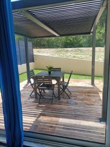 eine Terrasse mit einem Tisch und Stühlen auf einer Terrasse in der Unterkunft Villa du soleil in Les-Pennes-Mirabeau