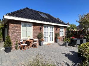 een stenen huis met een patio met een tafel en stoelen bij De Kamperveste in Kampen