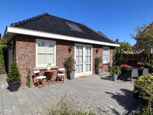 a brick house with a patio with a table and chairs at De Kamperveste in Kampen
