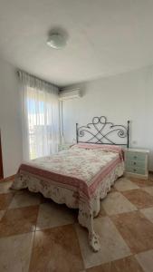 1 dormitorio con 1 cama con manta roja y blanca en Casa Santuario de Regla, en Chipiona