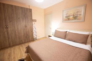ein Schlafzimmer mit einem großen Bett und einem Schrank in der Unterkunft Korca Luxury Apartments & Rooms in Korçë