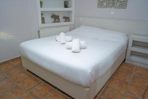 a white bed in a room with towels on it at Ktima Faki in Litochoro