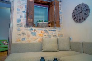 a living room with a couch and a clock on the wall at Ktima Faki in Litochoro