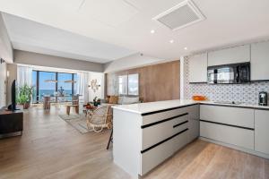 a kitchen with white cabinets and a living room at HiBird- Apartment and Suites Hotel in San Juan
