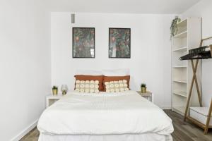 ein weißes Schlafzimmer mit einem großen Bett mit weißer Bettwäsche in der Unterkunft Plisson - Peaceful apartment near metro in Saint-Mandé