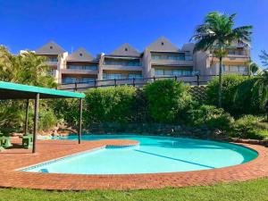 a swimming pool in front of a building at Salt Rock Ocean Views in Sheffield Beach