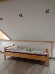 a bed in a room with a white wall at Agroturystyka u Chlebków in Ochotnica Górna