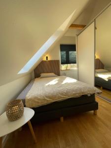 1 dormitorio en el ático con 1 cama y 1 mesa en Jelling, en Jelling