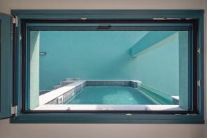 Blick auf den Pool durch ein Fenster in der Unterkunft Villa Gonates in Limenaria