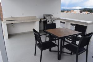 eine Küche mit einem Tisch und Stühlen im Zimmer in der Unterkunft Apartamento lujoso junto al lago in Paipa