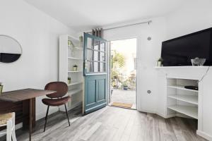 ein Heimbüro mit einer blauen Tür, einem Tisch und einem Stuhl in der Unterkunft Plisson - Peaceful apartment near metro in Saint-Mandé