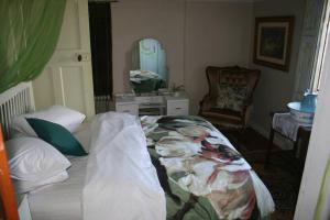 a bedroom with a bed and a mirror and a chair at Koringberg siding cottage in Koringberg