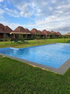 una piscina en medio de un patio con casas en Heart and Soul Lodge, en Karatu