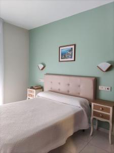 Un dormitorio con 2 camas y una mesa con luces. en Hotel Bonaire, en A Revolta