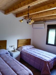 Habitación con 2 camas y lavabo. en Casa Marcelinas por habitaciones en Samper del Salz