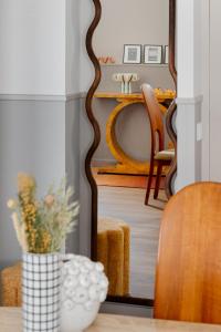 un jarrón con flores en una habitación con mesa en Edgar Suites Montmartre - Paul Albert, en París