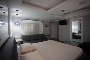 a bedroom with a bed and a couch and a mirror at Hotel Show Adult Only in Rio de Janeiro