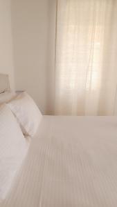 een wit bed in een slaapkamer met een raam bij Spilia in Stavros