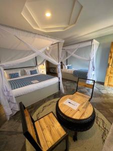 een slaapkamer met twee bedden en een tafel en een tafel sidx sidx sidx bij Heart and Soul Lodge in Karatu