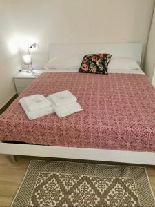 una camera da letto con un letto e due asciugamani di Casa Sant'Anna a Levanto